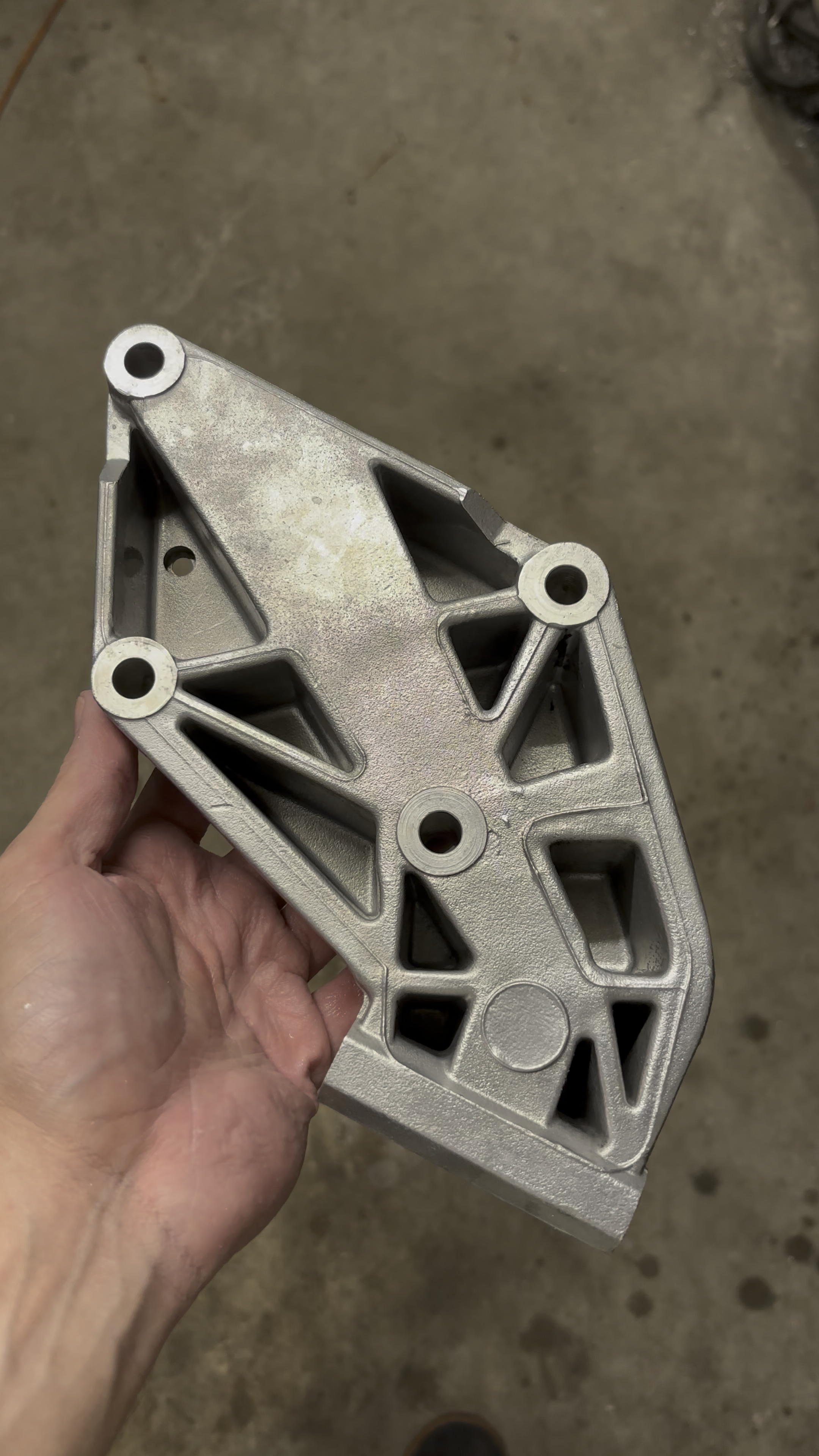 Porsche 944 alternator bracket after vapor blasting, clean even satin aluminium finish