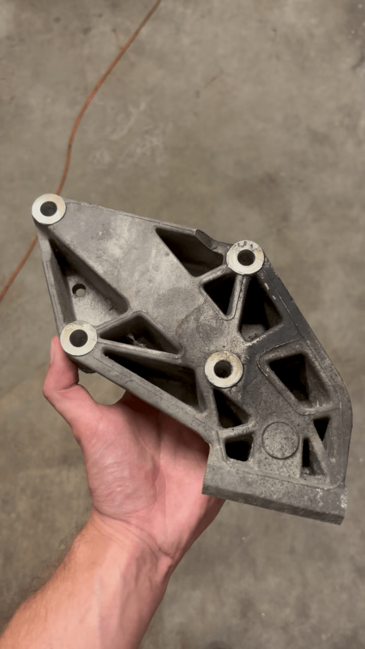 Porsche 944 alternator bracket before vapor blasting, dull and covered in oxidation